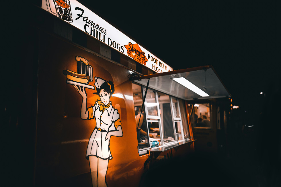 En färgstark foodtruck serverar läckra rätter till gästerna under bröllopsfesten, skapar en avslappnad och rolig atmosfär.