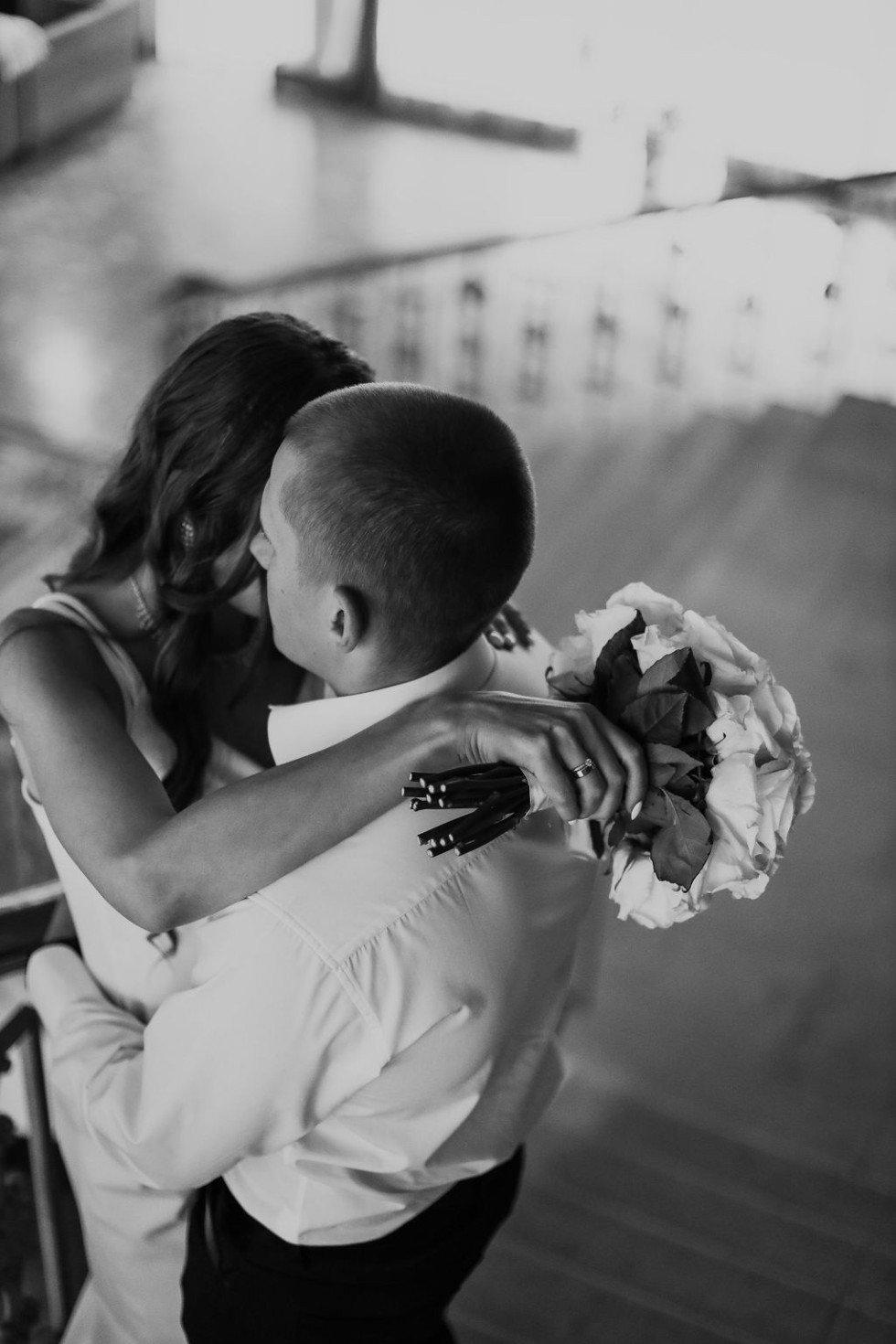 Brudpar som kramar varandra med kärleksfulla blickar, omgivna av en romantisk bröllopsatmosfär.