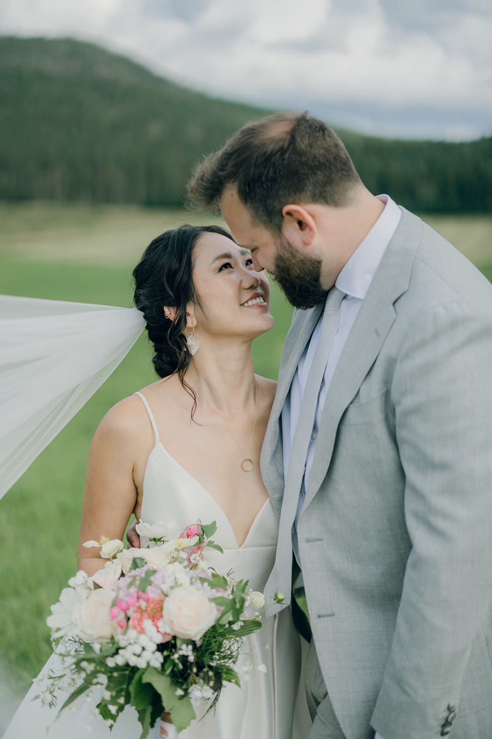 ett bröllopspar som kysser varandra i naturen