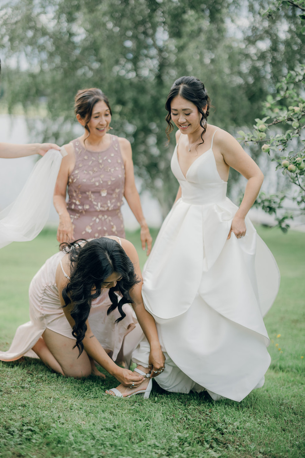 bröllopstärnor som hjälper en brud med en sko