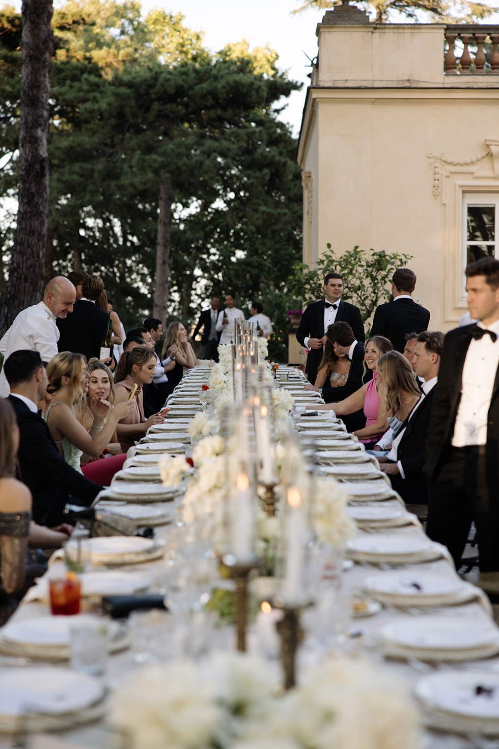 Bröllopsgäster sitter samlade vid ett vackert dukat långbord under middagen