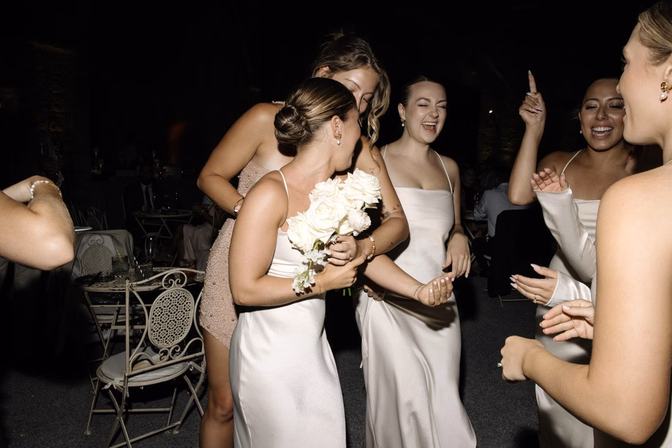 Glade jenter ler sammen under et utdrikningslag utendørs