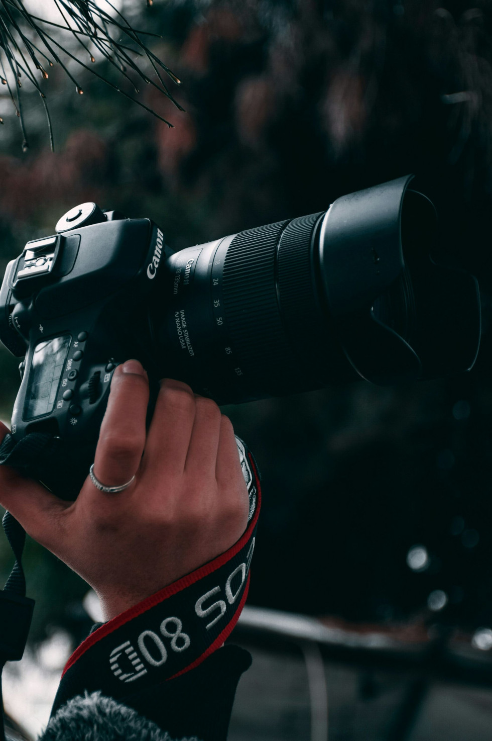 Professionell bröllopsfotograf håller i en stor systemkamera, förberedelser inför fotografering med vår fotochecklista bröllop.