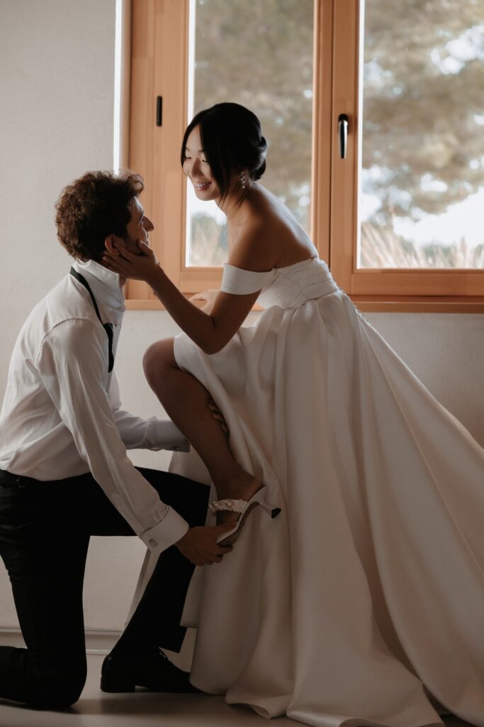 Wedding Photographer Stockholm – Felicia Margineanu: Candid shot of groom putting shoe on bride.