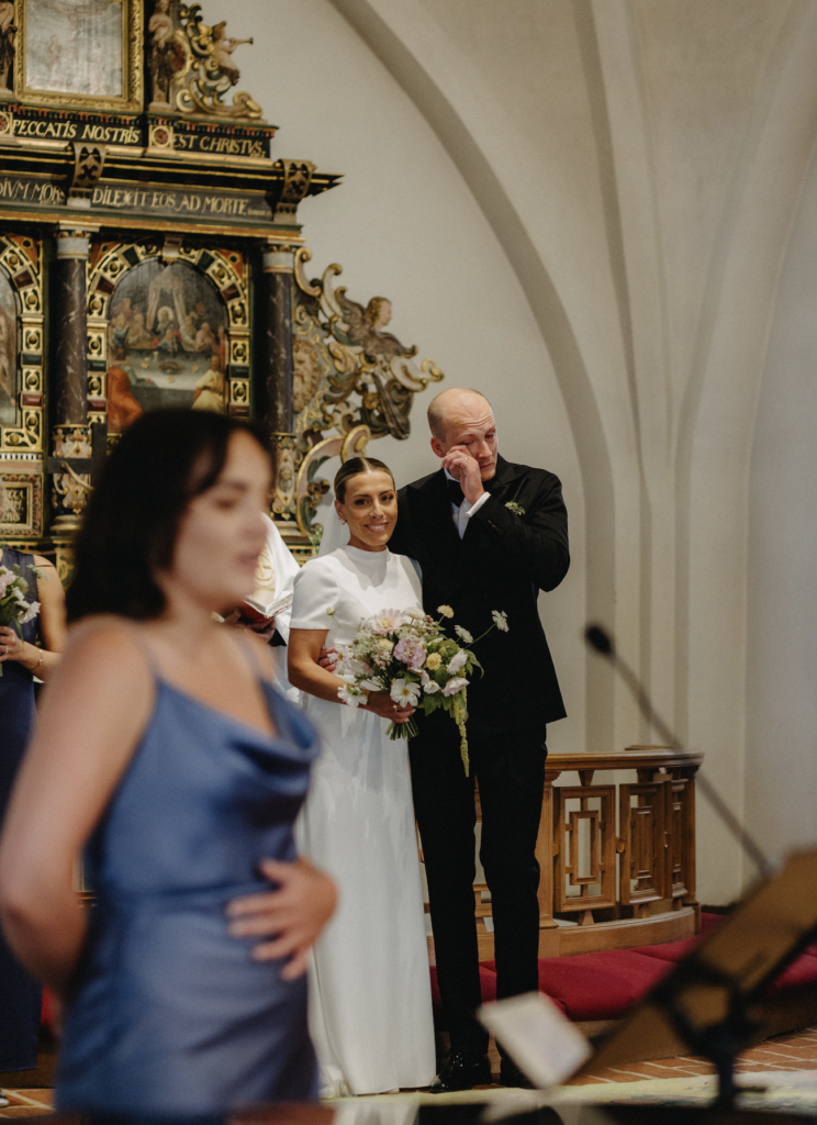 Psalmer på bröllop sjungs av gästerna i en vackert dekorerad kyrka under en sommarvigsel.