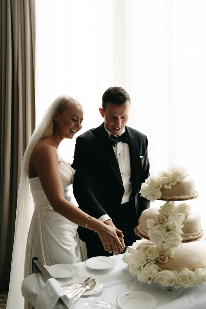 Brudparet skär tårtan tillsammans vilket är en klassisk tradition inom vett och etikett bröllop.