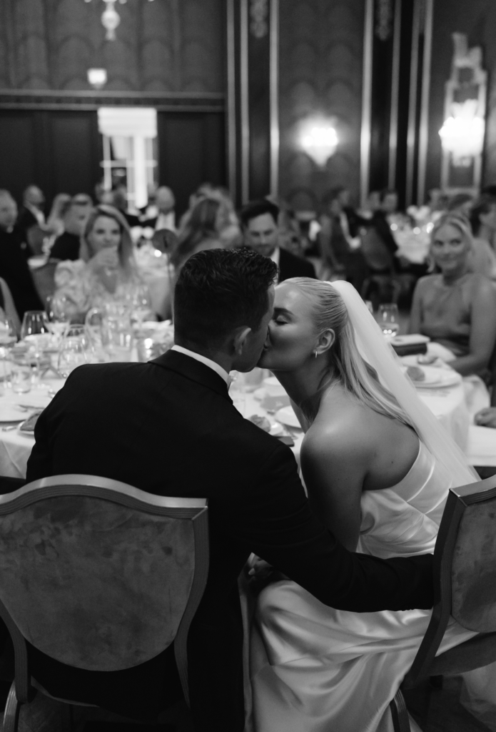 Ett lyckligt ögonblick och vett och etikett bröllop när brudparet delar en kyss.