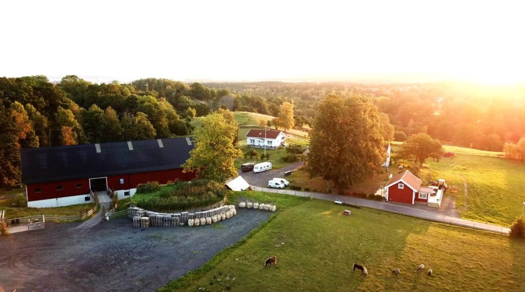Vy över Ängens Gård och Bårarps Loge i Jönköping – en rustik bröllopsmiljö med lada, gröna ängar och hagar.