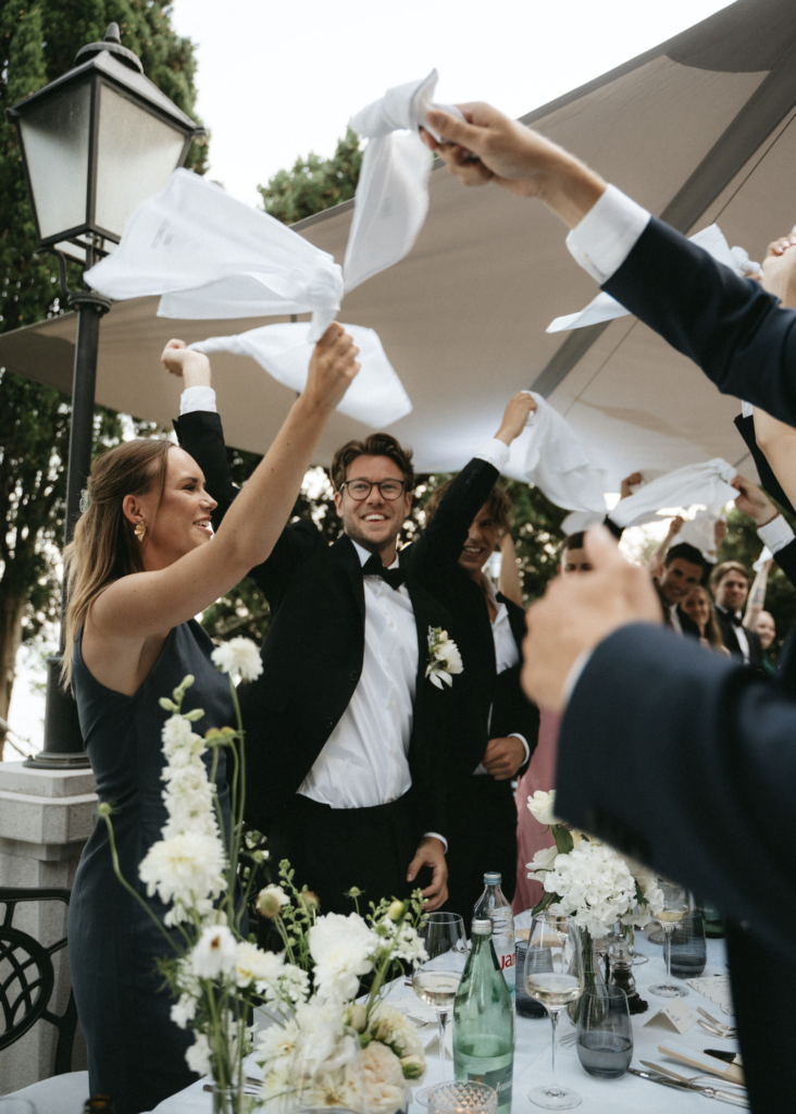 Nye bryllupstradisjoner: Modern Wedding Rules. Bryllupsgjester som vifter med hvite duker for å feire brudeparet under en personlig fest.